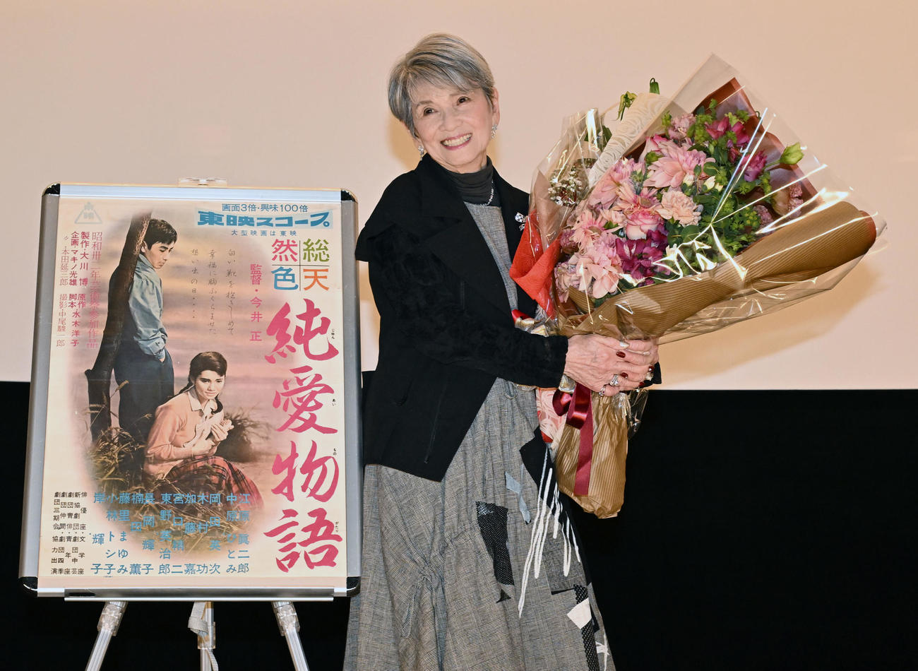 映画「純愛物語」の舞台あいさつで麻雀仲間から贈られた花束を手に笑顔を見せる中原ひとみ（撮影・千葉一成）