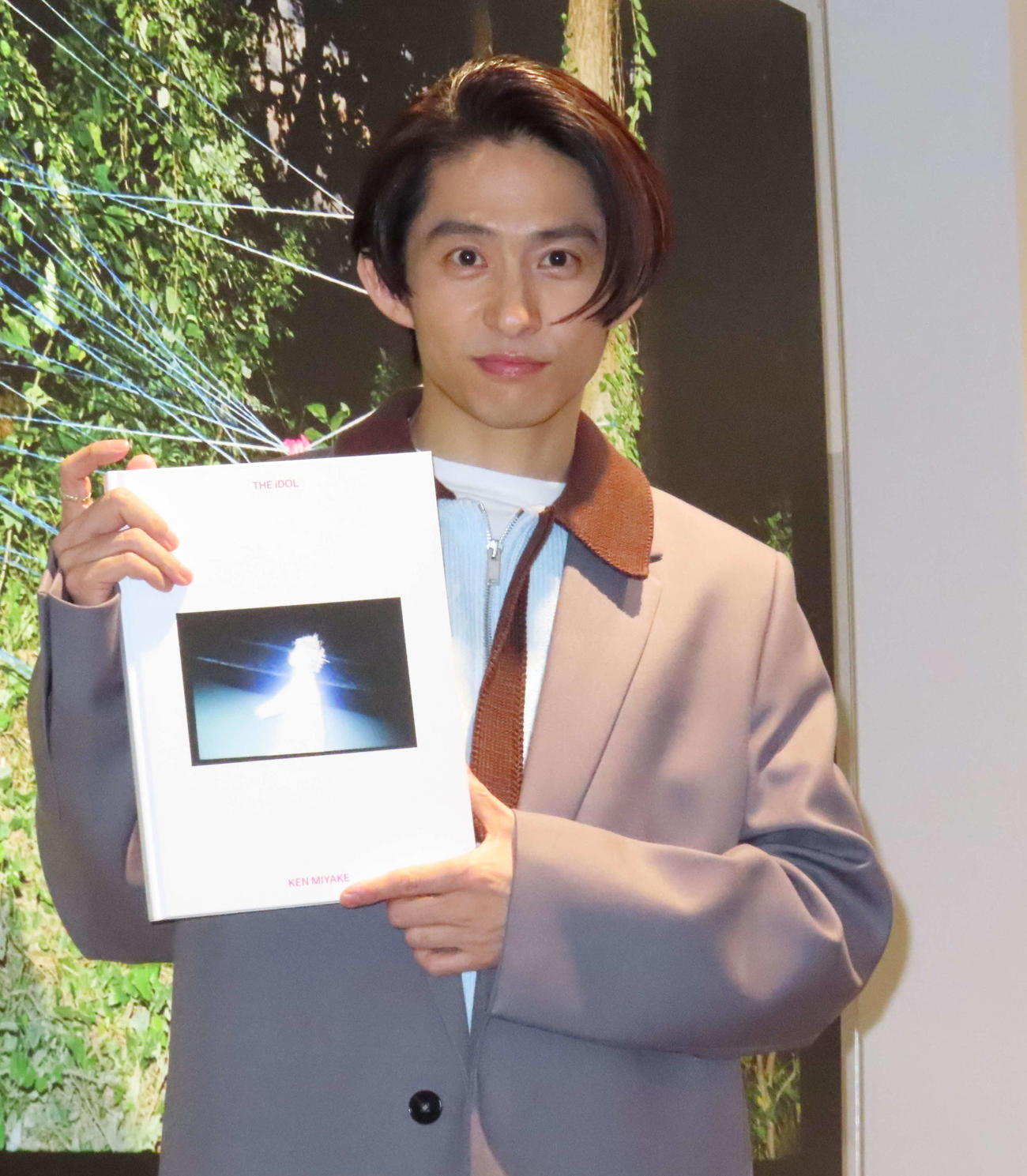 写真展「KEN MIYAKE PHOTO EXHIBITION　“THE iDOL”」会場で写真集を手にする三宅健