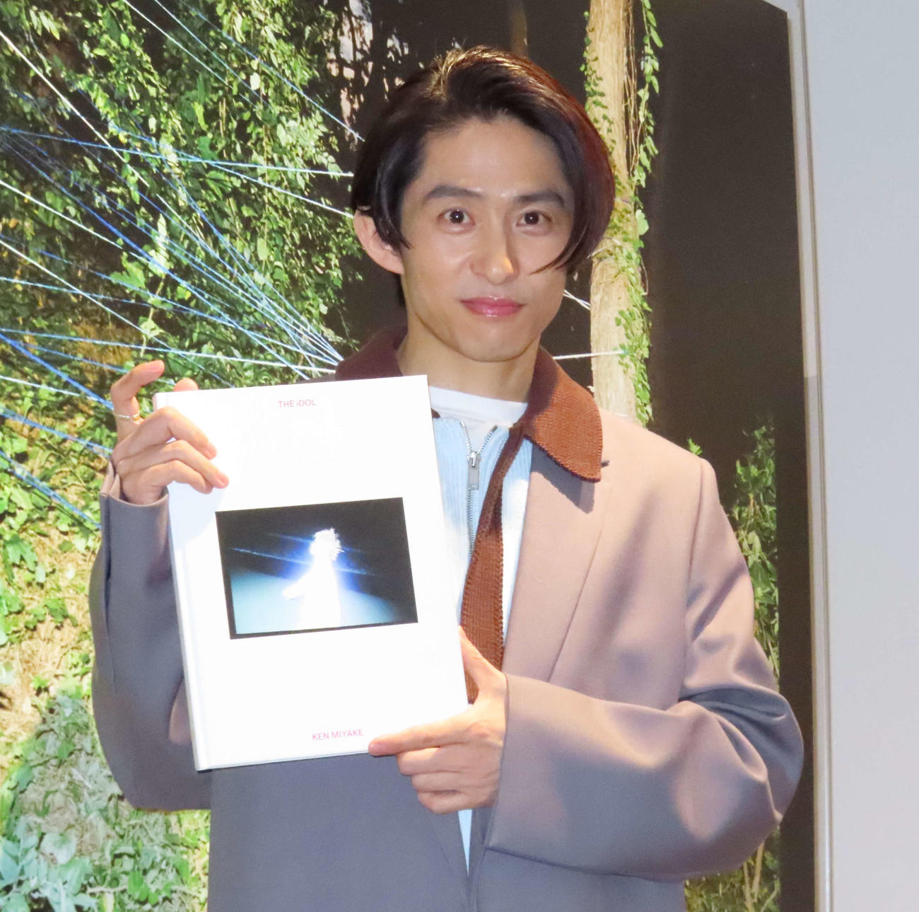 写真展「KEN MIYAKE PHOTO EXHIBITION　“THE iDOL”」会場で写真集を手にする三宅健