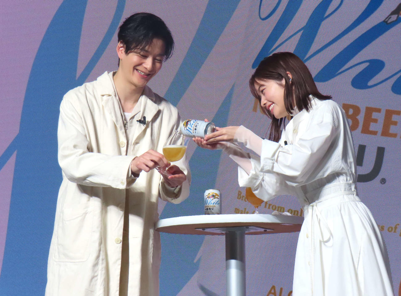 「一番搾り　ホワイトビール」を注ぎ合う岡田将生（左）と小芝風花