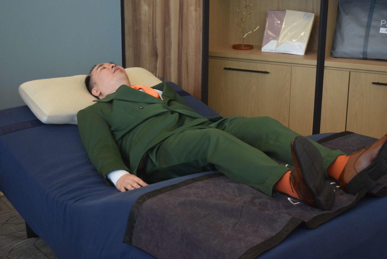 パラマウントベッド「Active Sleep BED」を体験し、気持ちよさそうなミルクボーイ内海崇（撮影・阪口孝志）
