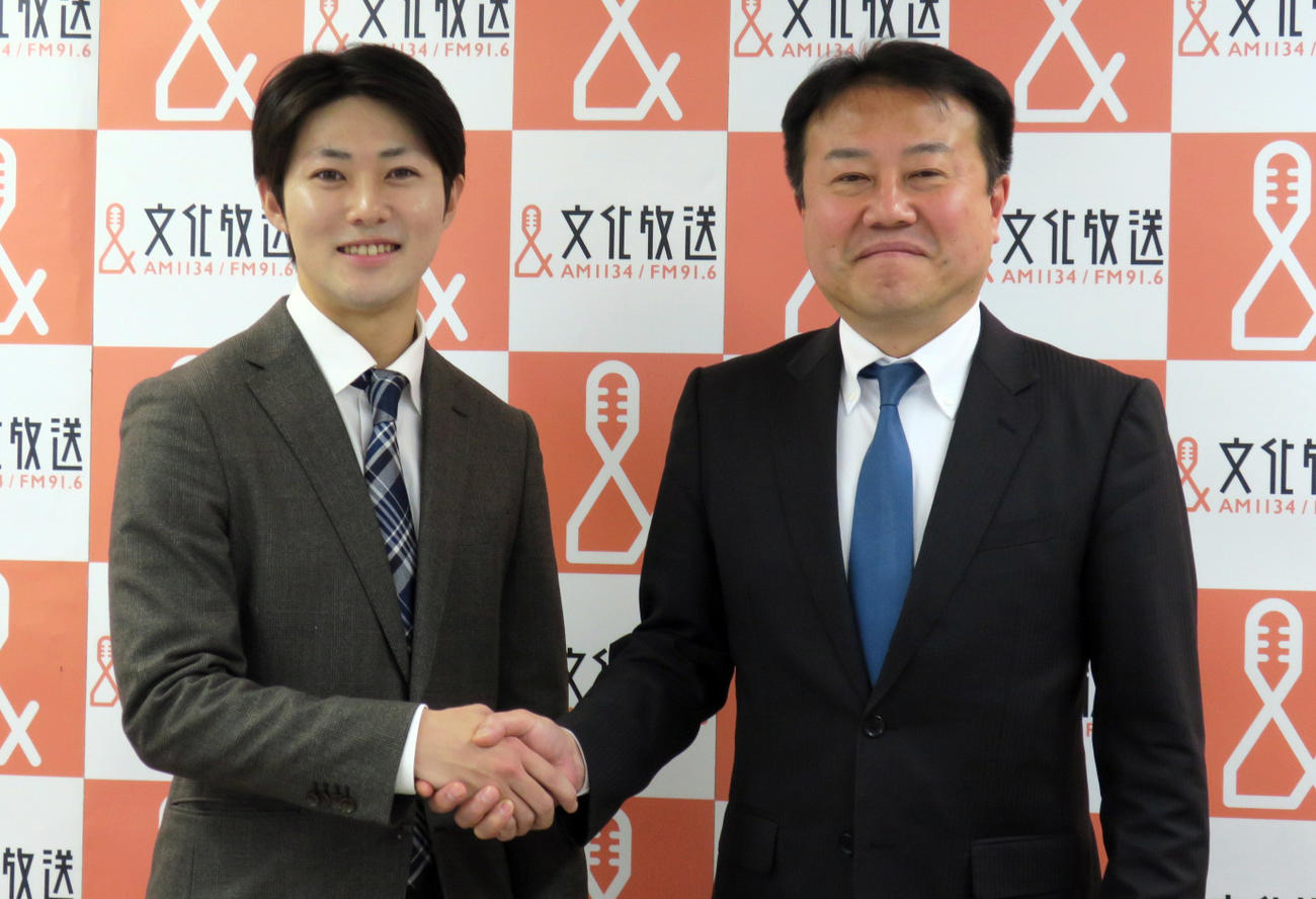 文化放送定例会見で齋藤清人社長（右）と握手する小宅世人アナウンサー