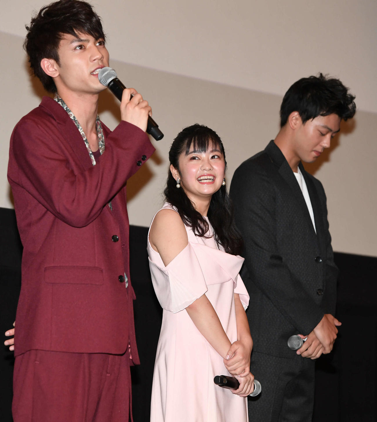映画「初恋ロスタイム」の完成披露上映会で、吉柳咲良は板垣瑞生さん（左）のあいさつに笑顔を見せる。右は竹内涼真（2019年9月撮影）