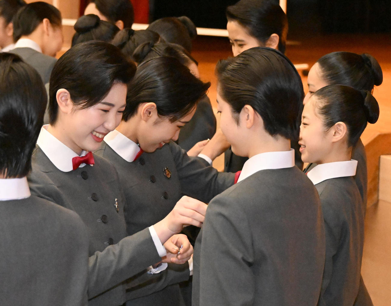 在校生から校章バッチの贈呈を受ける新入生ら（撮影・石井愛子）