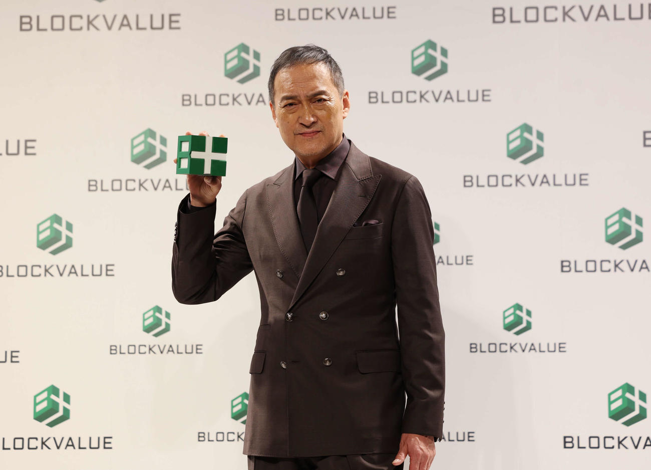 新CM発表会でロゴを持ち目線を向ける渡辺謙（撮影・増田悦実）