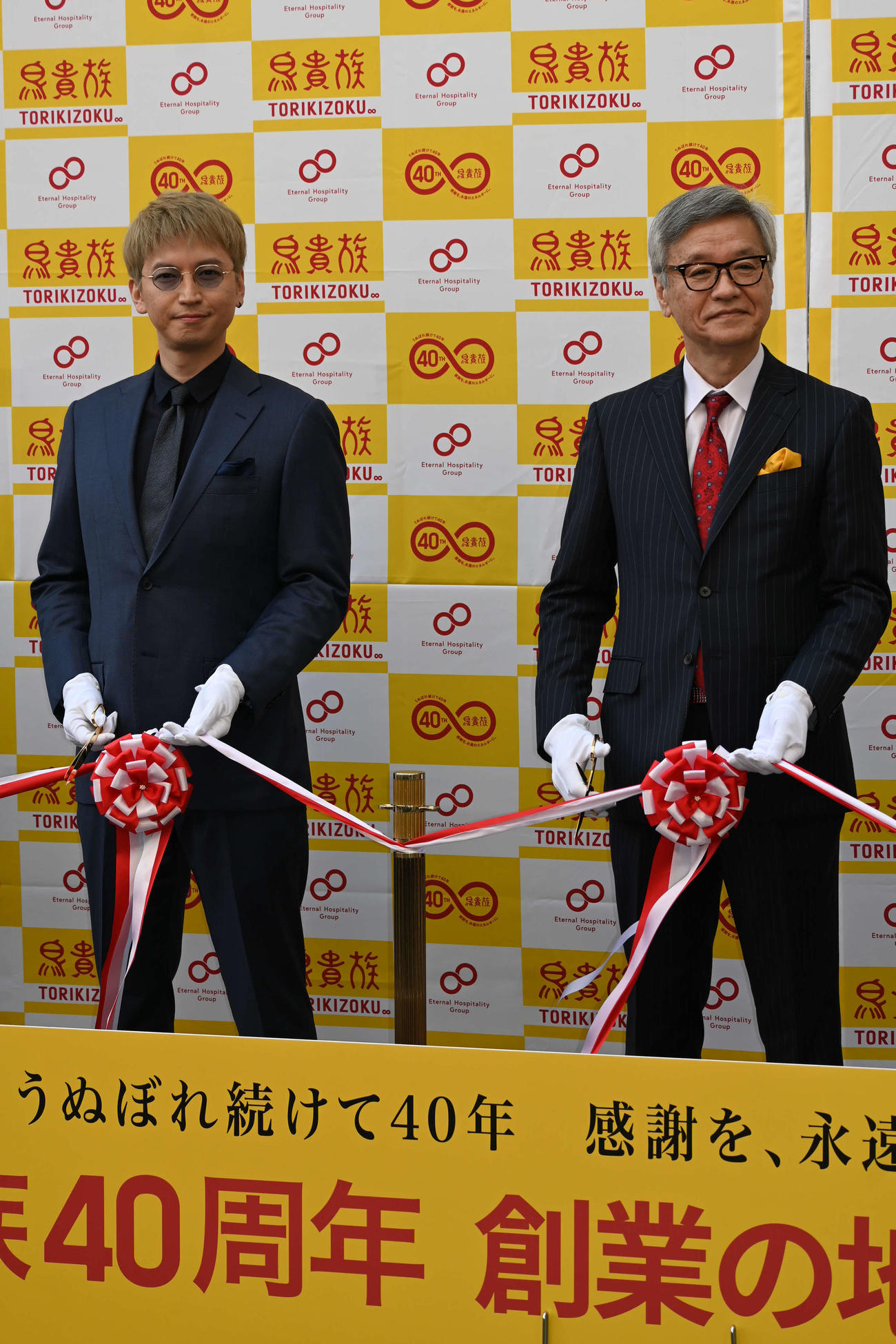 鳥貴族1号店「俊徳店」の復活プロジェクトのオープニングセレモニーで創業者である父、大倉忠司氏と並んでテープカットした大倉忠義（左）（撮影・松浦隆司）