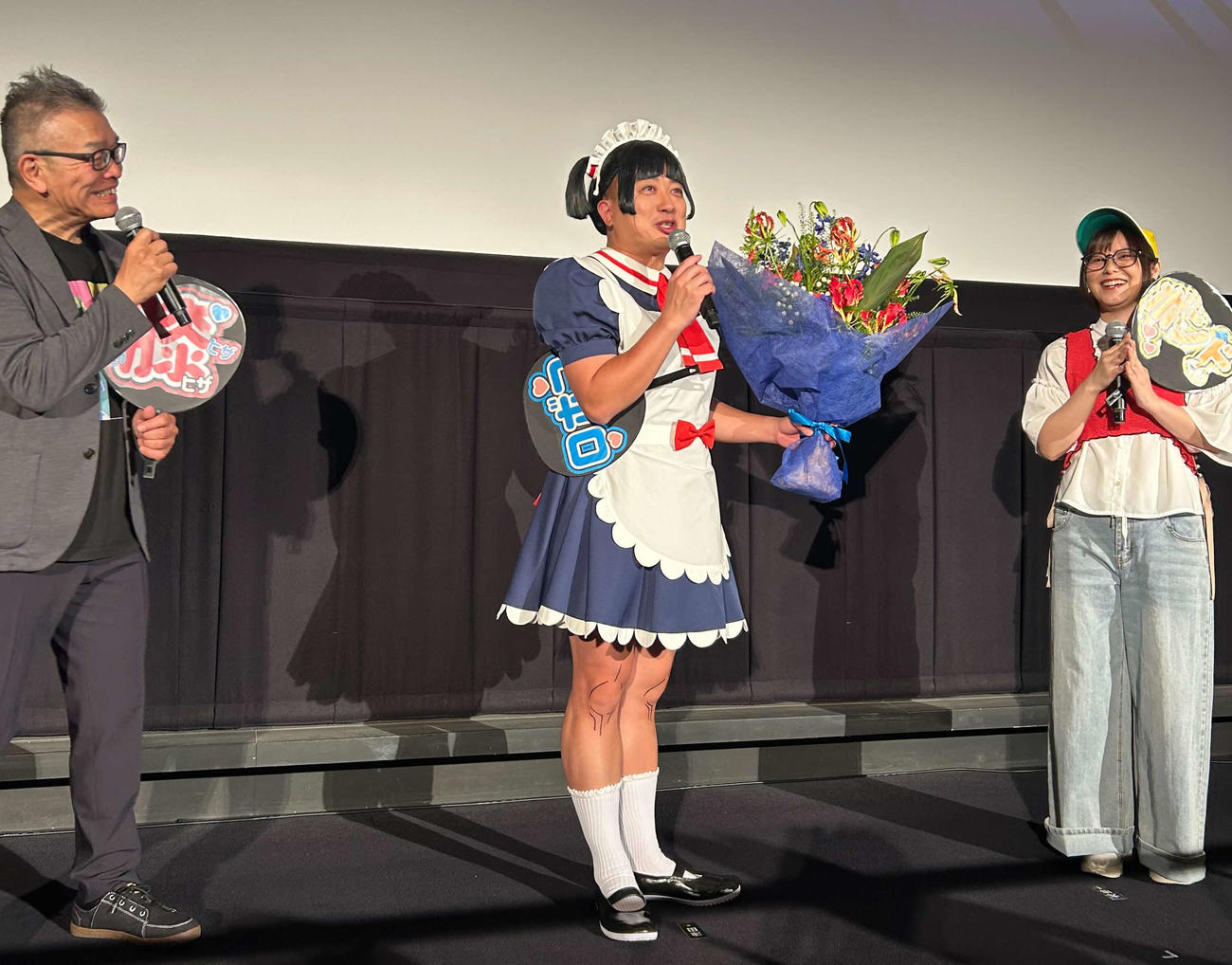 アニメ映画「劇場版『僕とロボコ』応援上映レクチャー付き大ヒット御礼舞台あいさつ」に登壇し、花束を受け取ったチョコレートプラネット松尾駿（中央）、右は津田美波、左は大地丙太郎監督