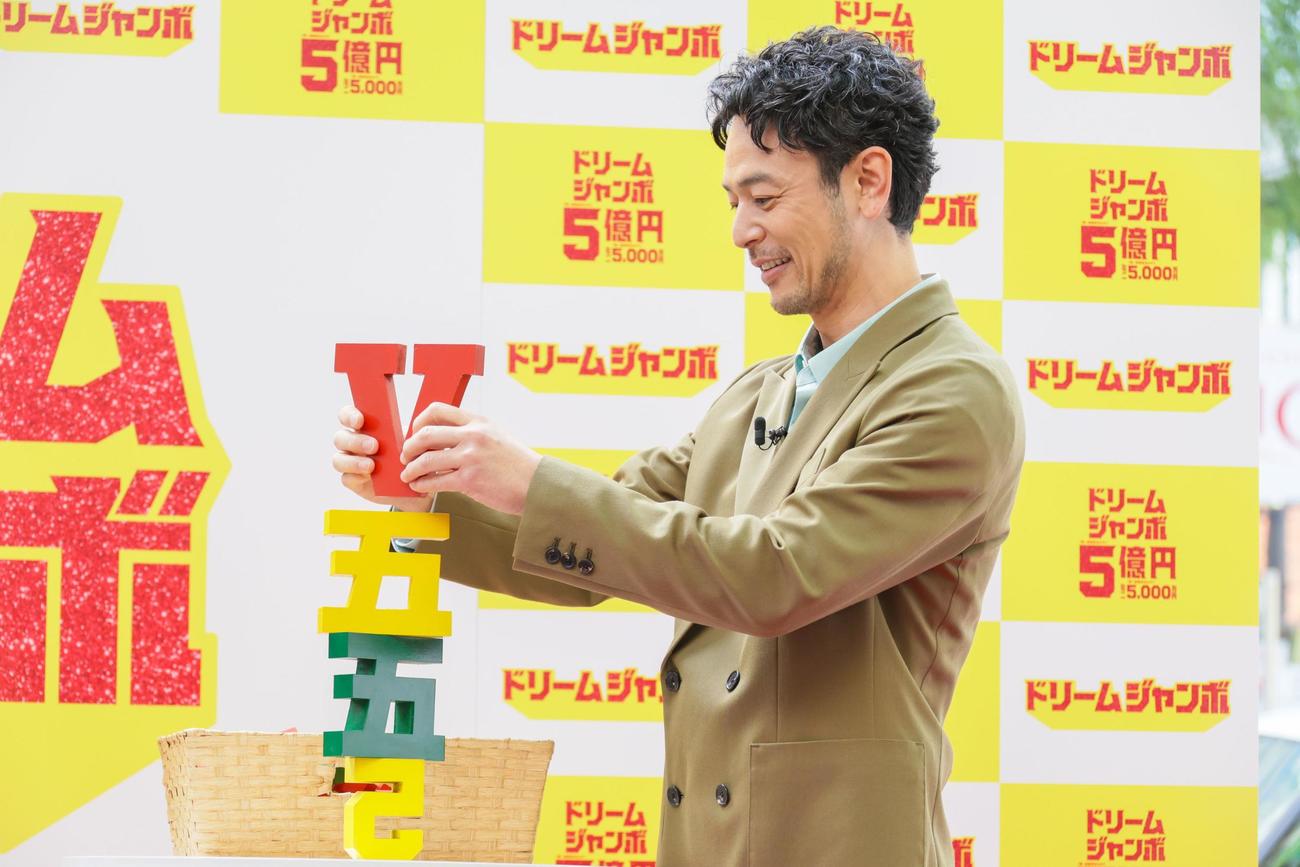 ドリームジャンボ宝くじの発売イベントで「5」の積み木を積み上げる妻夫木聡