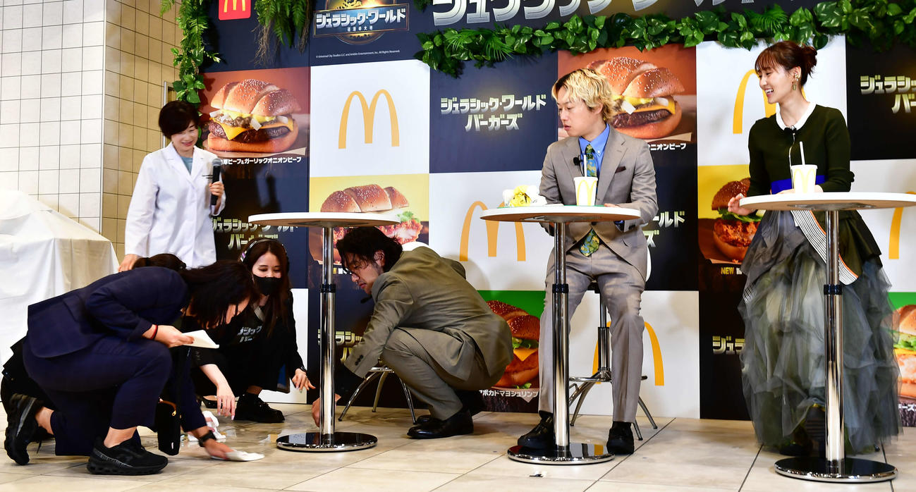 マクドナルドの「ジュラシック・ワールド　バーガーズ」新商品発表イベントで、スタッフらとこぼした水を拭き取る見取り図の盛山晋太郎（右から3人目）と、見守るリリー（同2人目）、菅井友香（右端）（撮影・松尾幸之介）