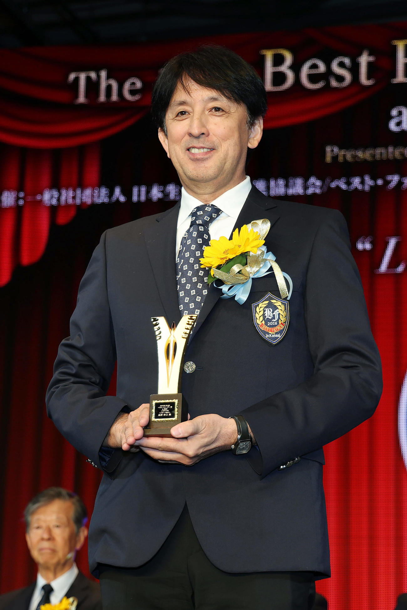 「2025年度　第18回ベスト・ファーザー賞in関西」の授賞式でトロフィーを手にする星野伸之氏（撮影・前田充）