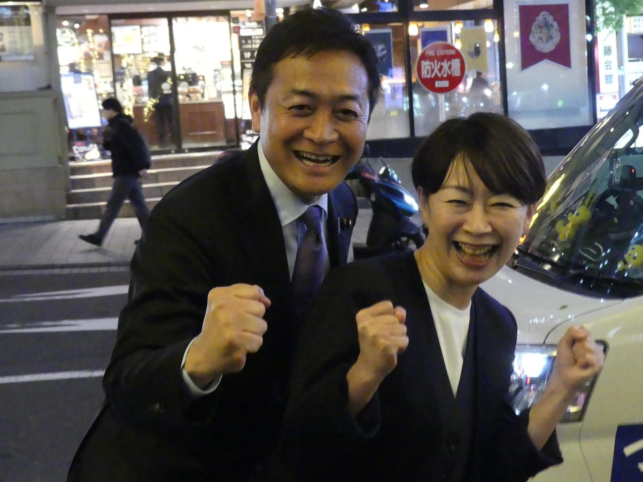 党の街頭演説後、カメラに向かって笑顔でポーズを取る国民民主党の玉木雄一郎代表（左）と山尾志桜里氏（2025年5月14日撮影）