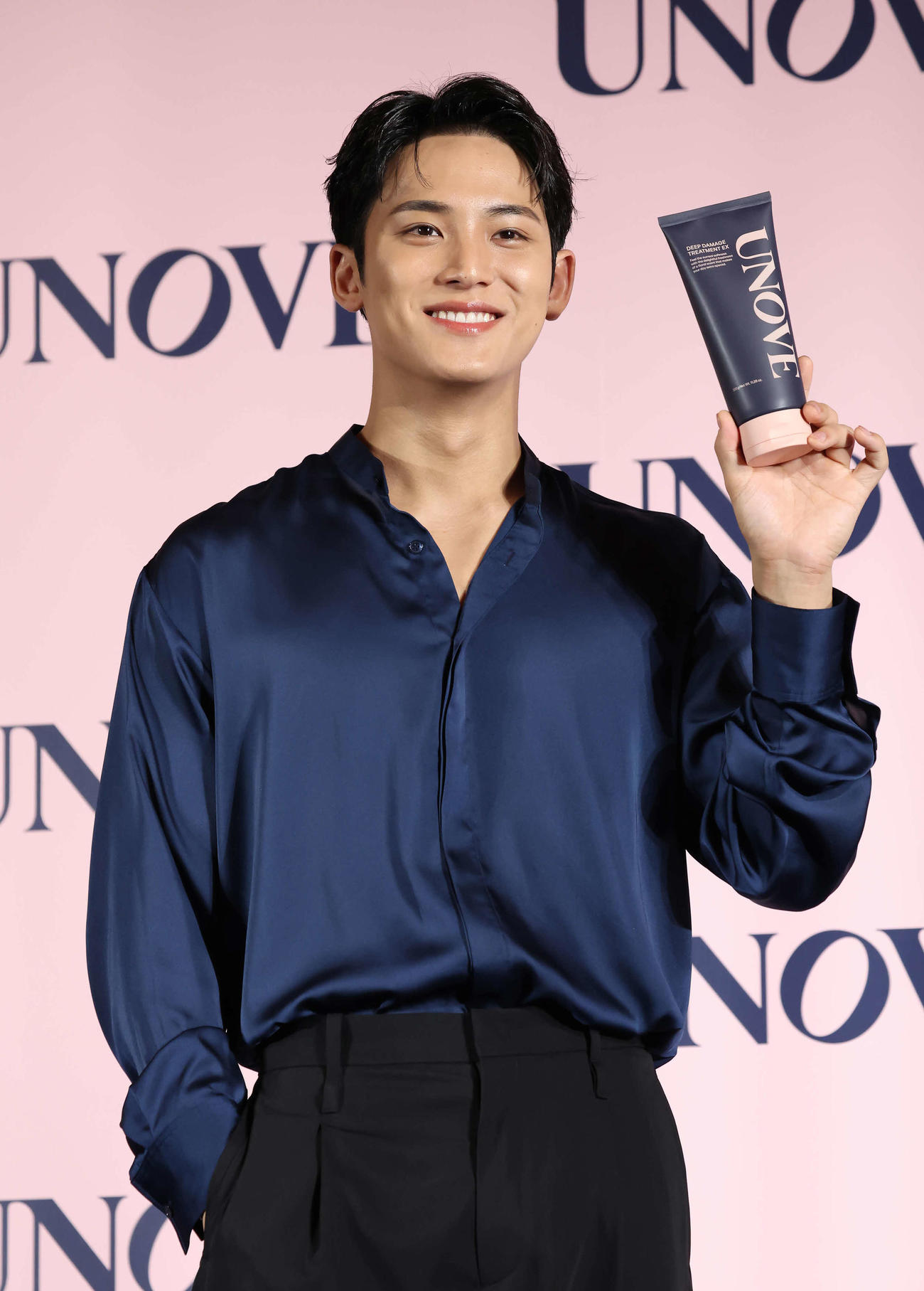 韓国発パーソナルケアブランド「UNOVE」の発表会で、商品を手に写真に納まるMINGYU（撮影・丹羽敏通）