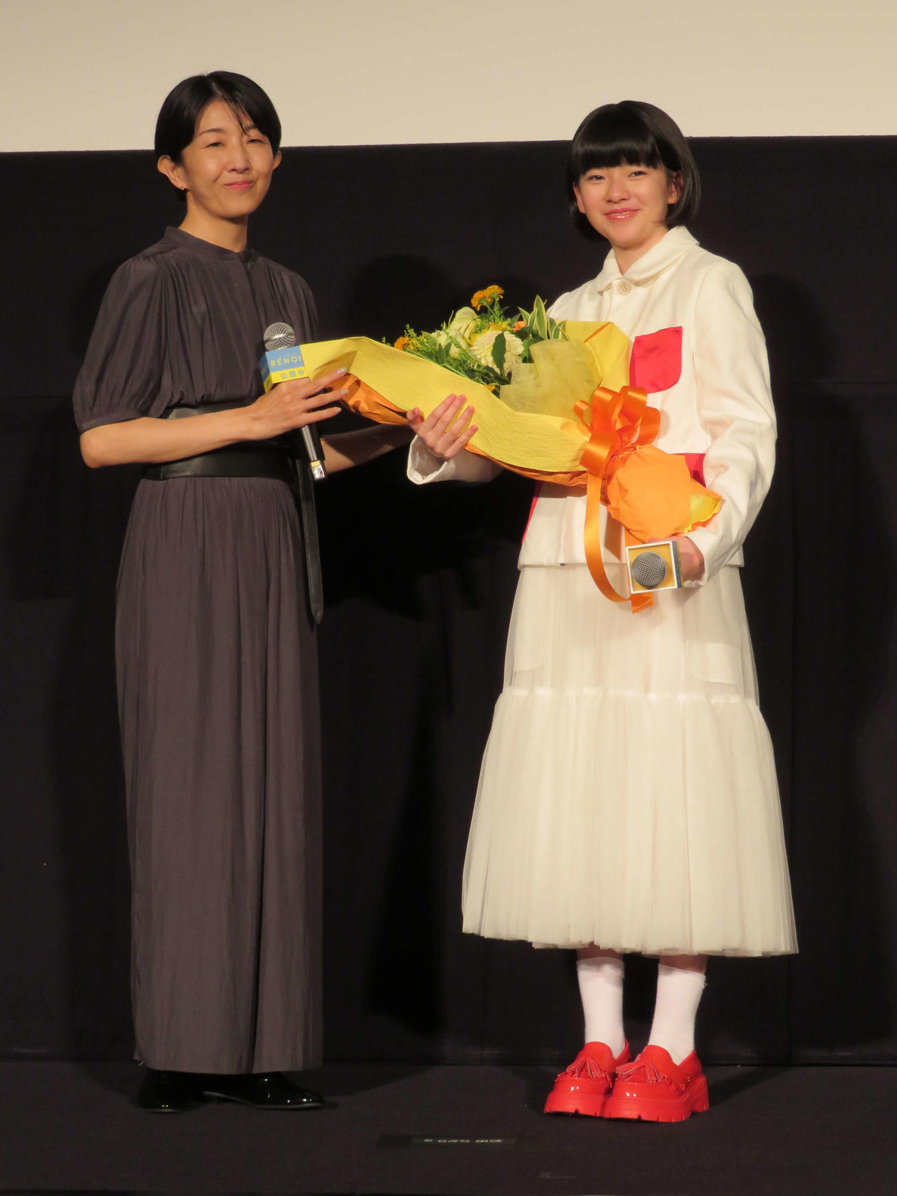 映画「ルノワール」公開記念舞台あいさつで、鈴木唯（右）に花束を贈る早川千絵監督（撮影・村上幸将）