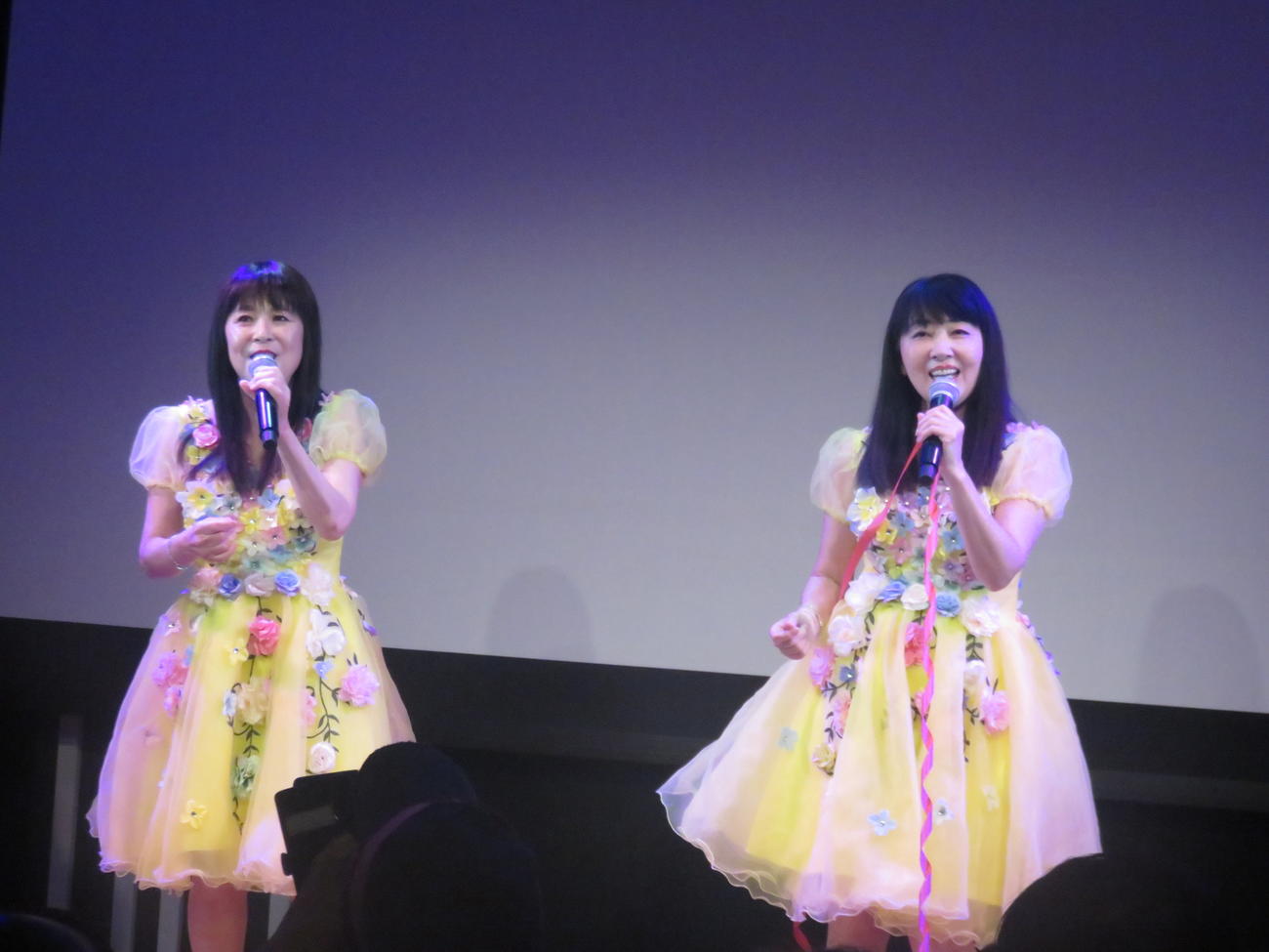 黄色いフリフリの衣装で昭和アイドルの歌を熱唱するmyun（左）とyayo