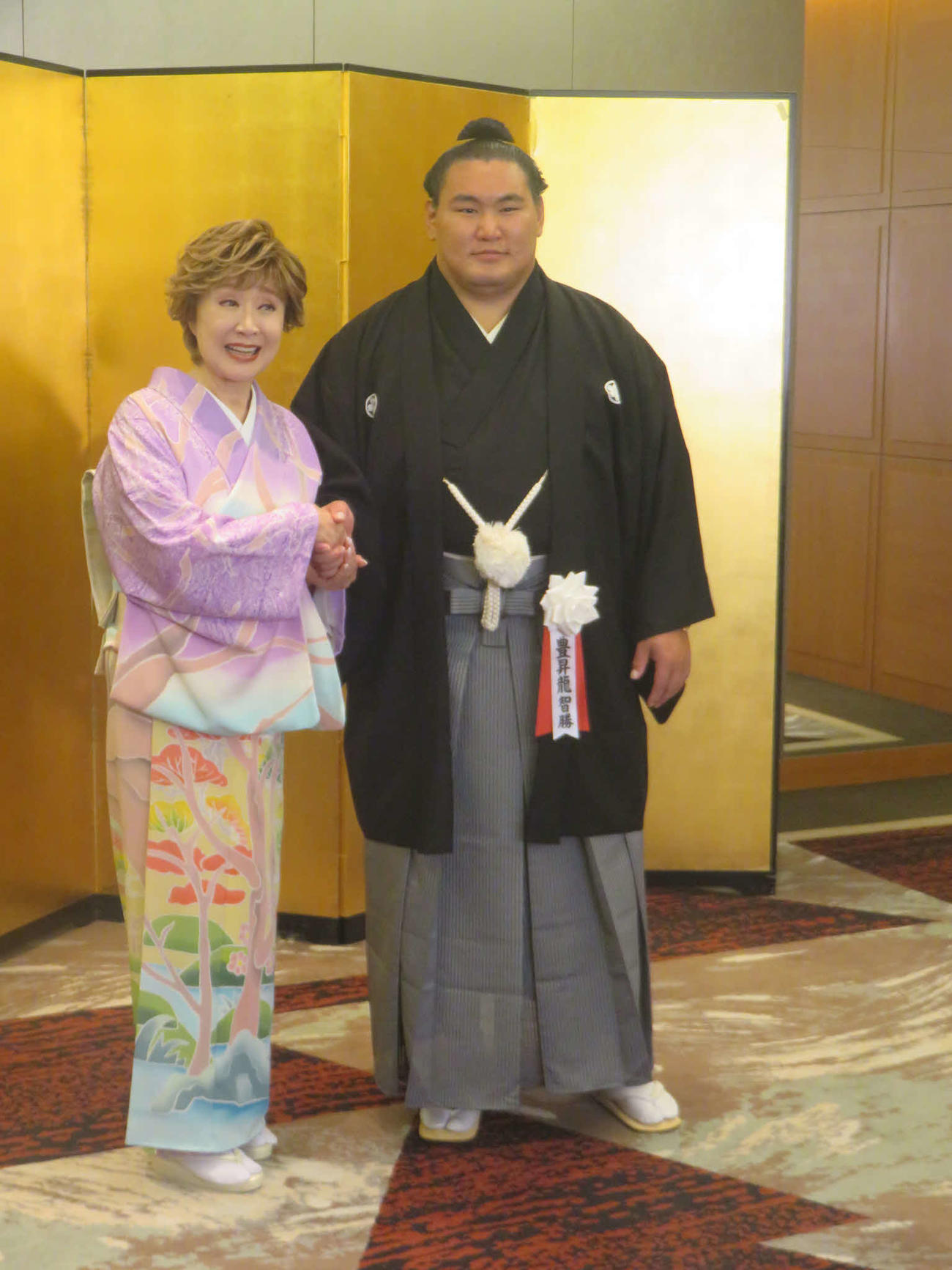 ガッチリ握手を交わして会見する小林幸子（左）と横綱豊昇龍