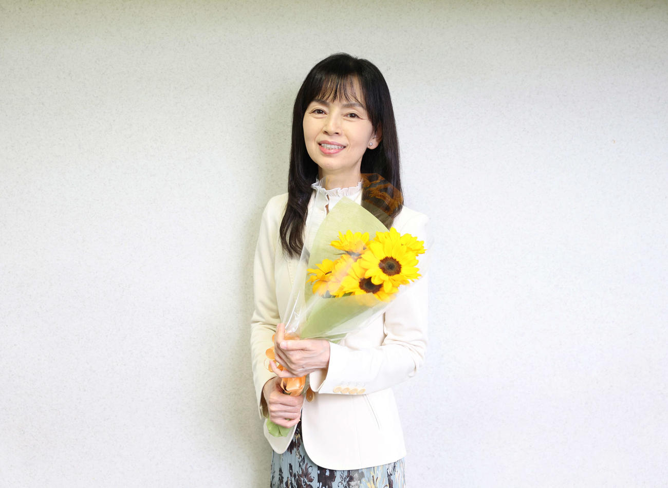 黄色の花束をもち笑顔の岡田奈々（撮影・増田悦実）