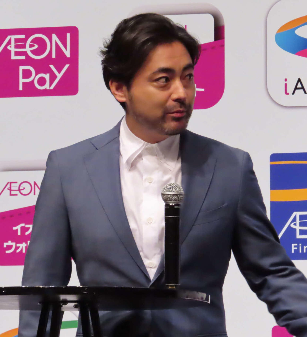 「AEON Pay」新CM発表会で、机にマイクを立てて話す山田孝之