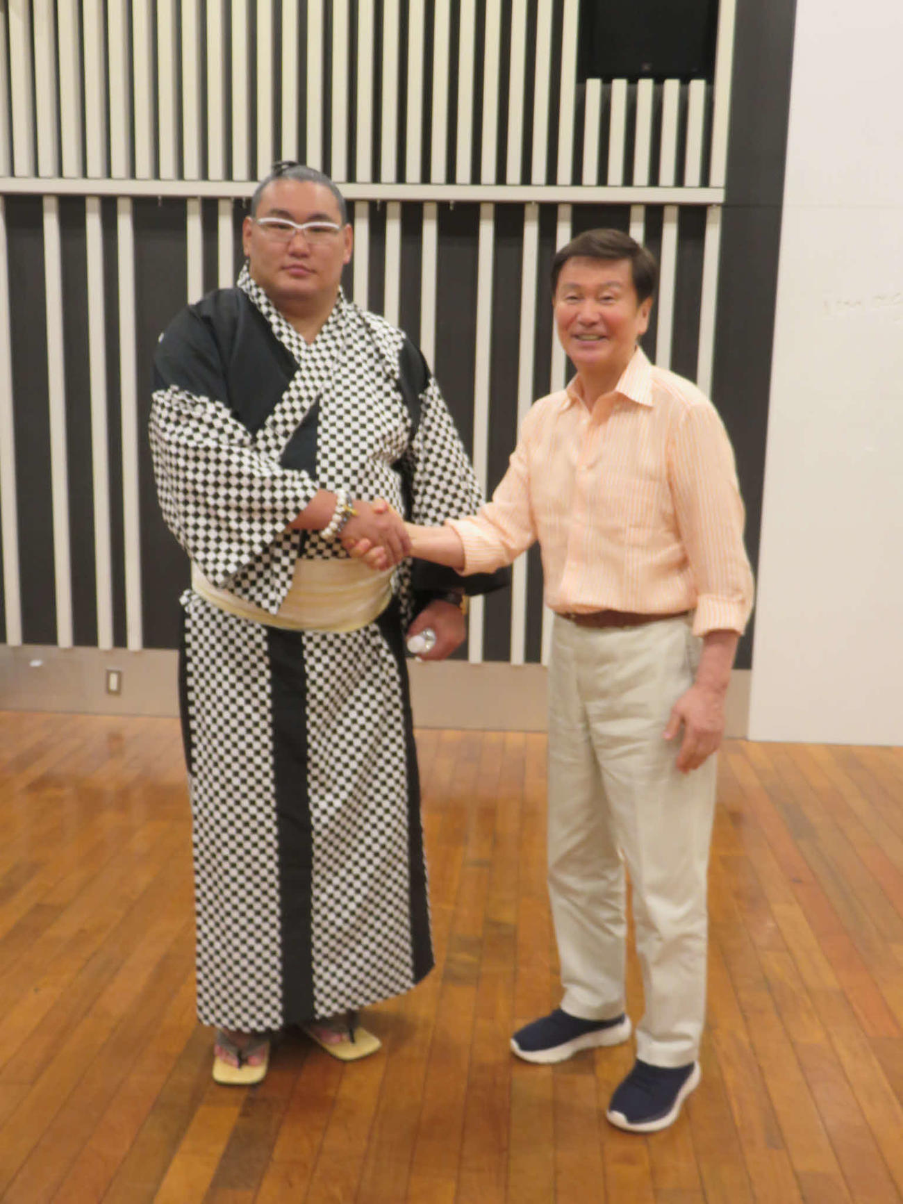横綱豊昇龍（左）とガッチリ握手する森田健作