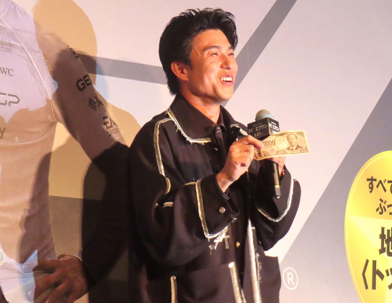 映画「F1／エフワン」舞台あいさつでブラッド・ピットにもらった1万円札を手に笑顔の中尾明慶