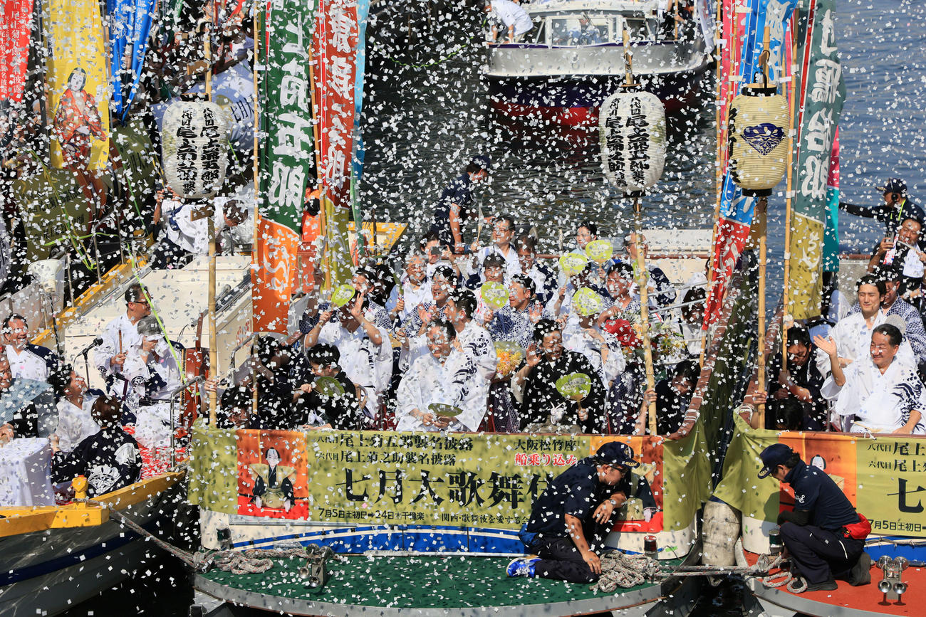 七月大歌舞伎を前に行われた船乗り込みで、紙吹雪が舞う中で戎橋に到着した、中央船前列左から六代目尾上菊之助、片岡仁左衛門、八代目尾上菊五郎ら（撮影・宮崎幸一)
