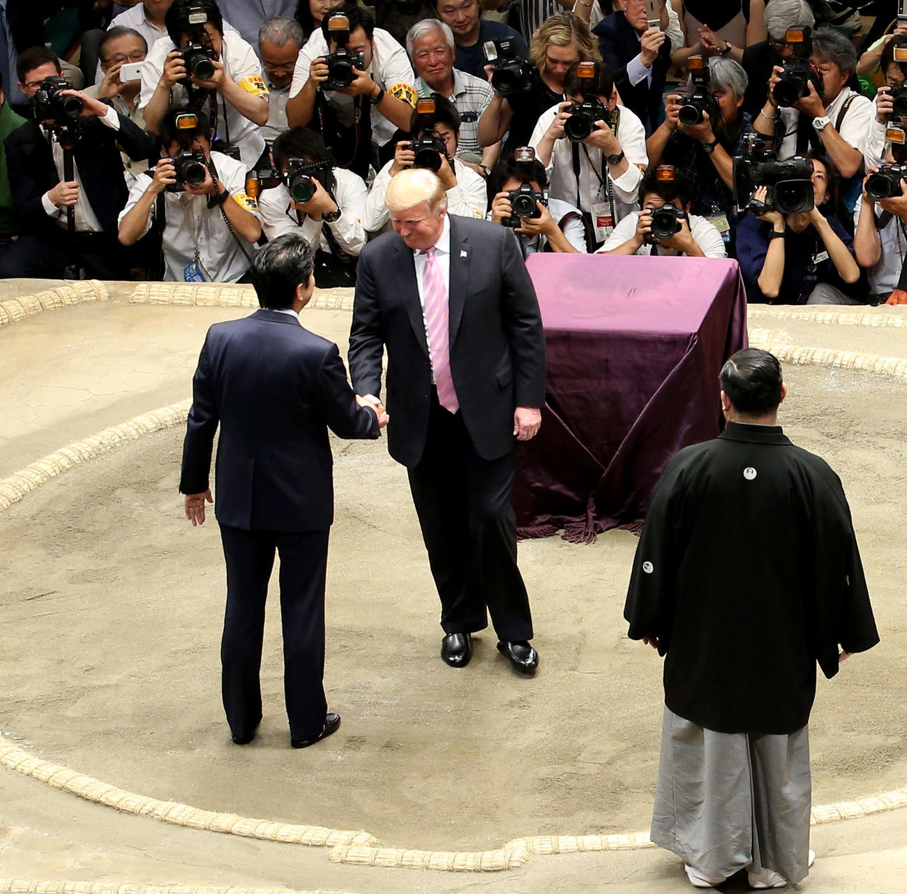 土俵上で安倍晋三首相（左）と笑顔で握手を交わすトランプ米大統領（中央）（2019年5月26日撮）