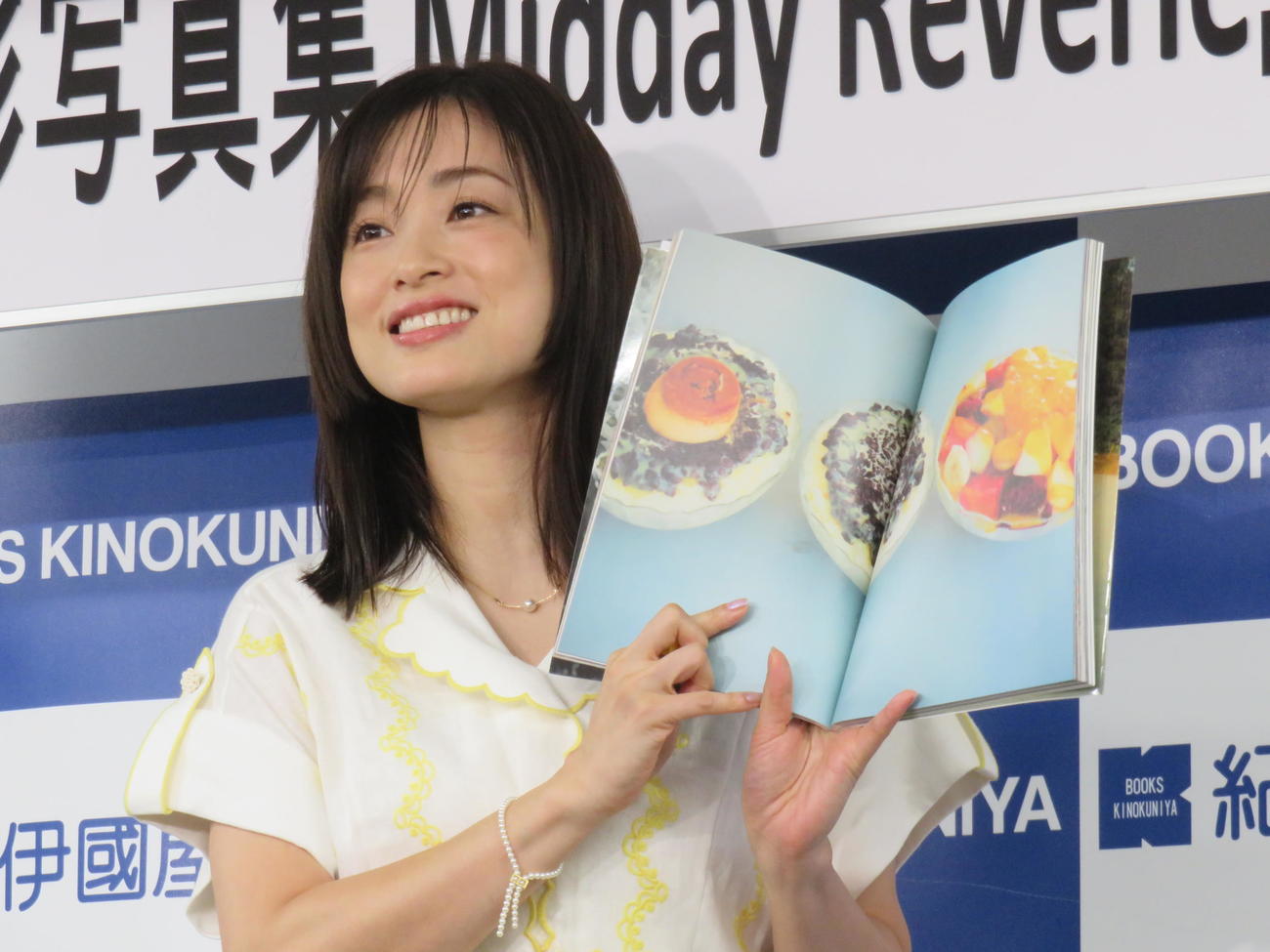 写真集「Midday Reverie」のお気に入りページを見せる上戸彩