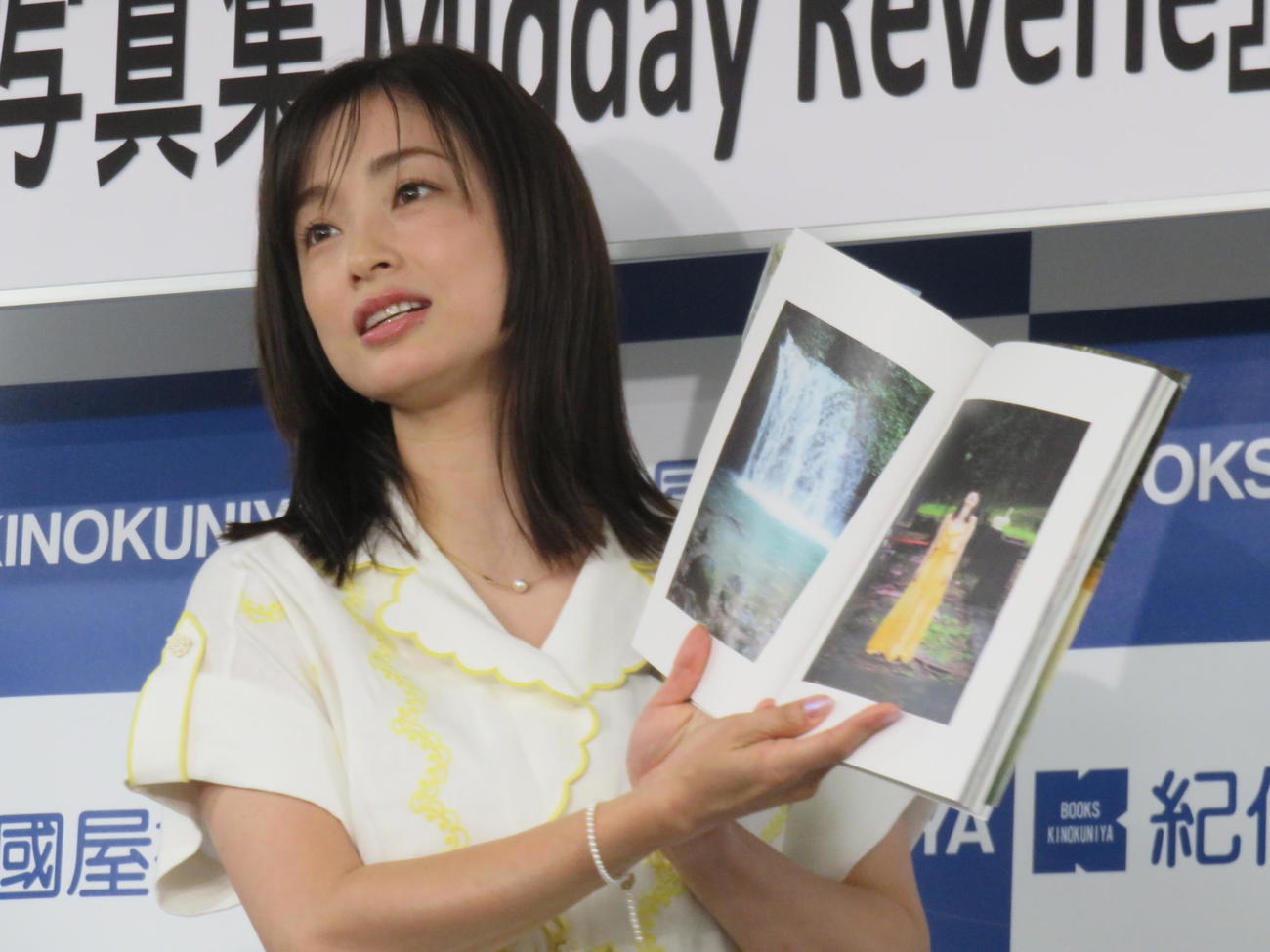 写真集「Midday Reverie」のお気に入りページを見せる上戸彩