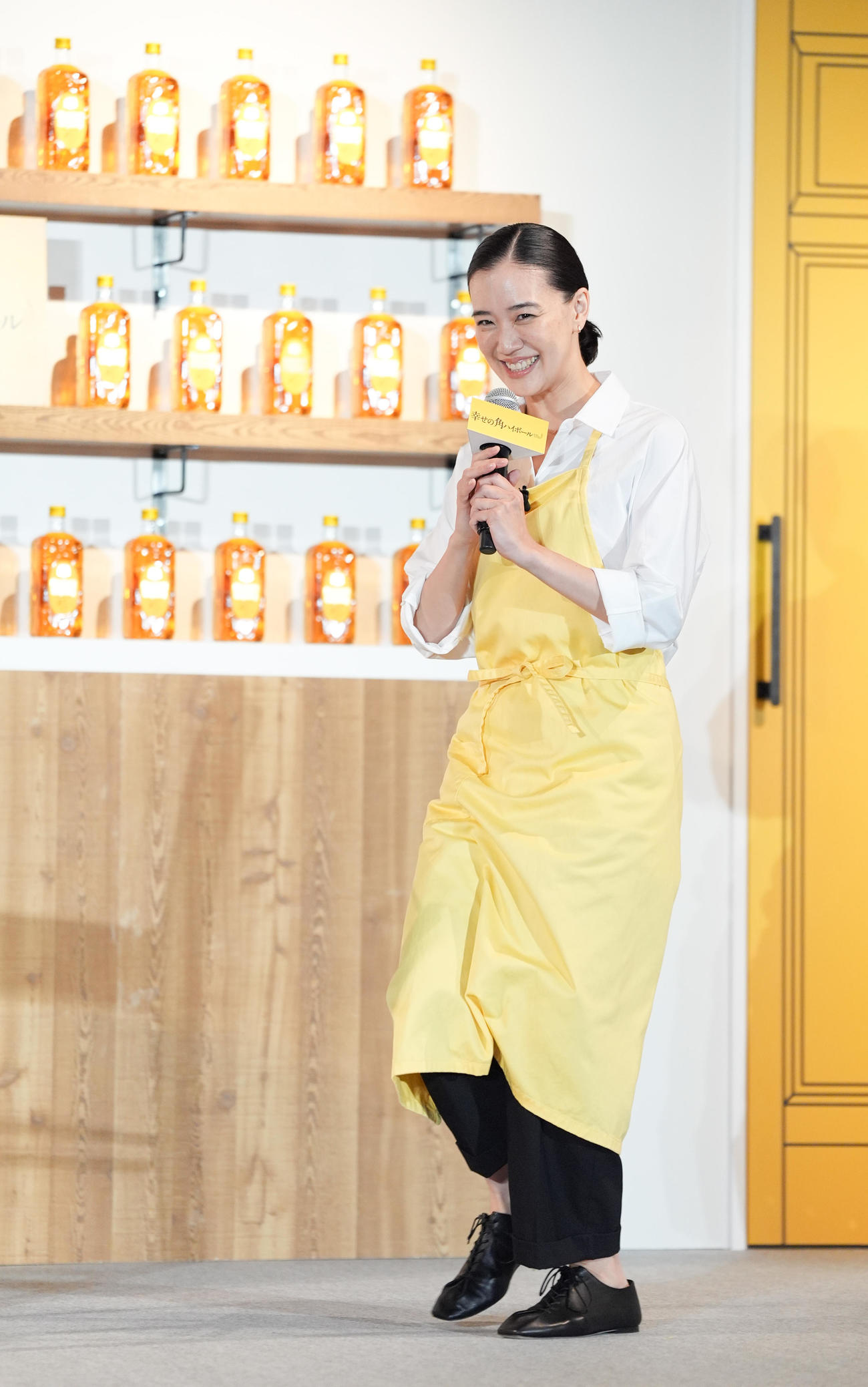 サントリーウイスキー「角瓶」新CM発表会で、新店主に就任した蒼井優は黄色いエプロンを着けて登場する（撮影・鈴木みどり）