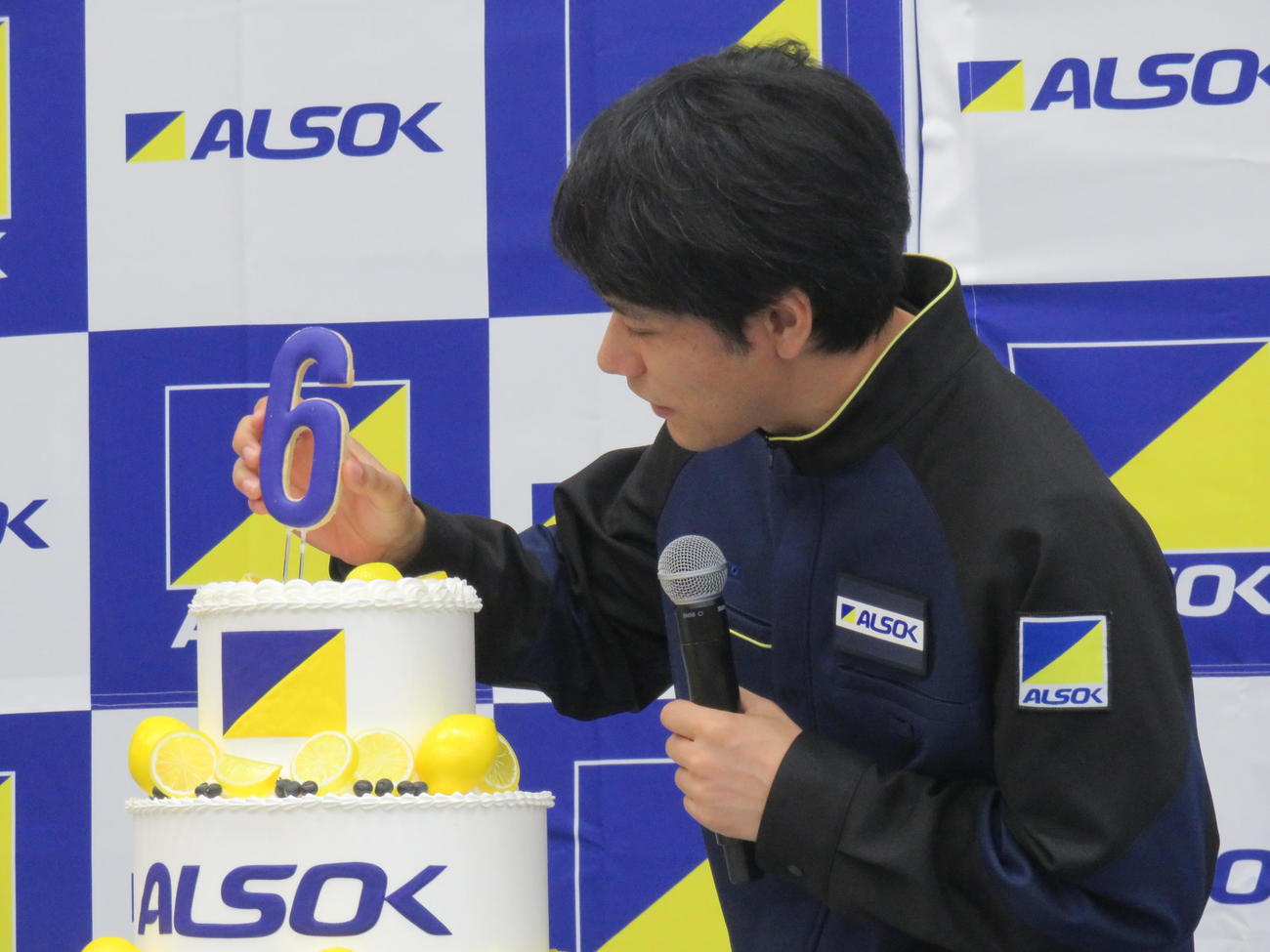 ALSOK60周年の記念ケーキに「60」のロウソクを立てる松山ケンイチ