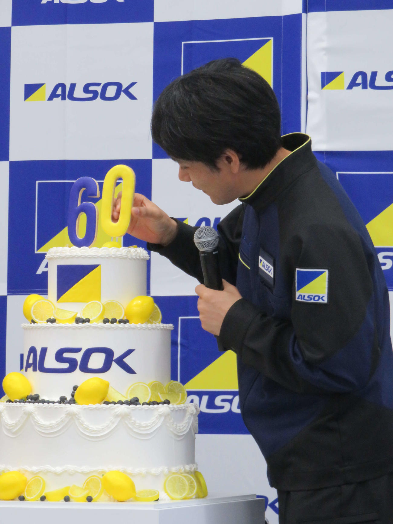 ALSOK60周年の記念ケーキに「60」のロウソクを立てる松山ケンイチ