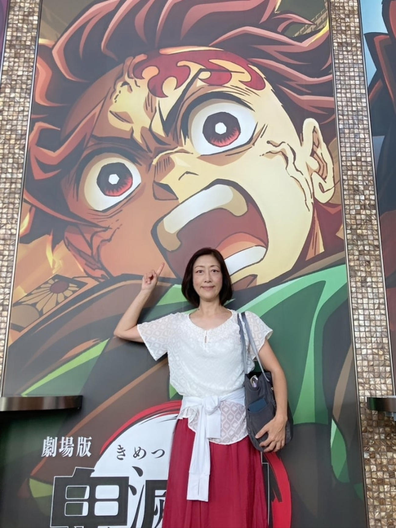 「鬼滅の刃」のポスターをバックにした伊藤みゆき（伊藤みゆきのブログから）