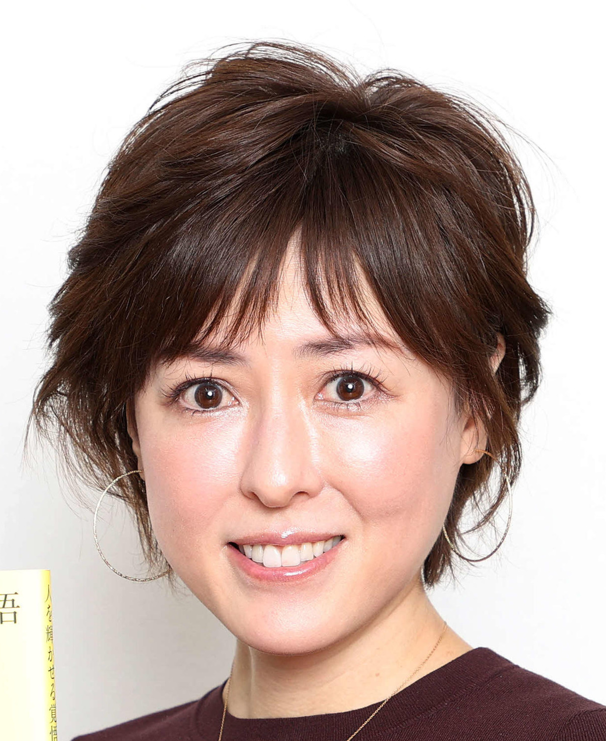 著書を手に写真に納まる大河内志保（撮影・鈴木正人）
