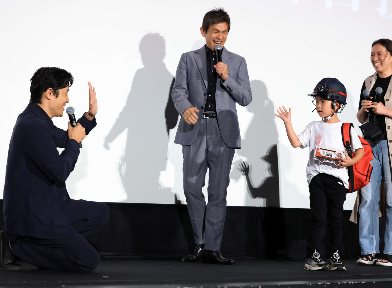 劇場版「TOKYOMER」大ヒット御礼舞台あいさつで、MERの完全装備で訪れたファンの少年に笑顔で手を振る鈴木亮平（左）。中央は江口洋介（撮影・浅見桂子）