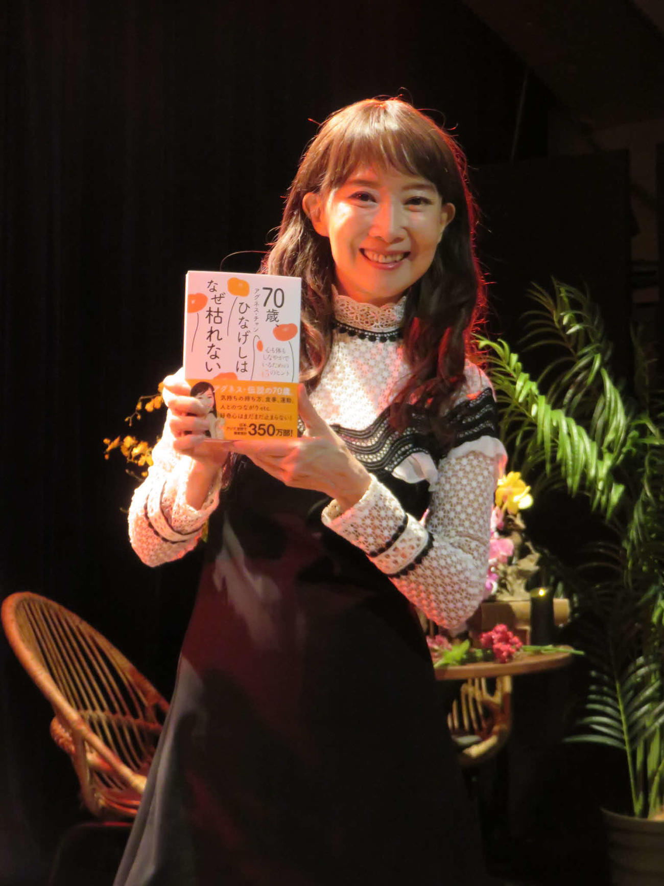 新刊「70歳、ひなげしはなぜ枯れない－心も体もしなやかでいられる45のヒントー」を手にするアグネス・チャン