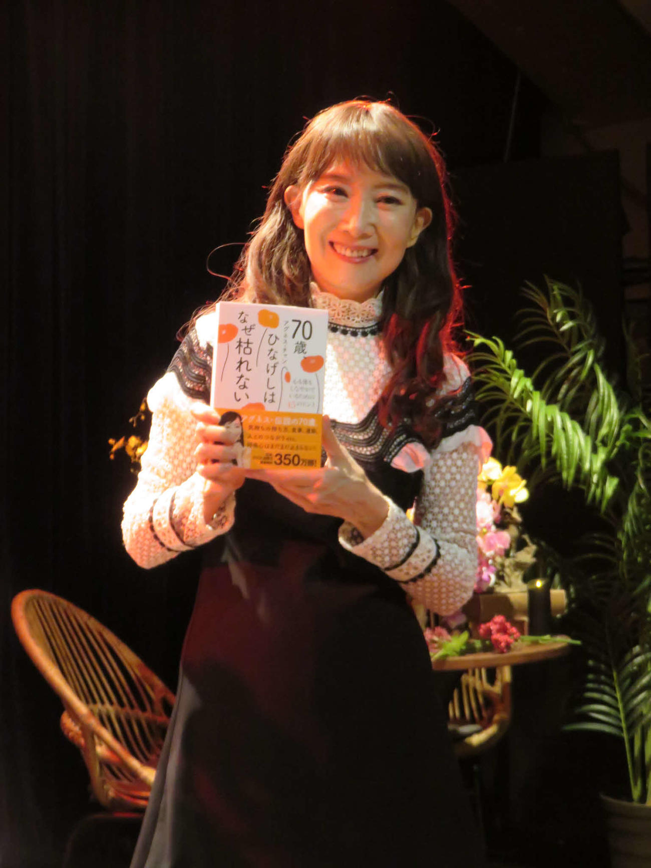 新刊「70歳、ひなげしはなぜ枯れない－心も体もしなやかでいられる45のヒントー」を手にするアグネス・チャン
