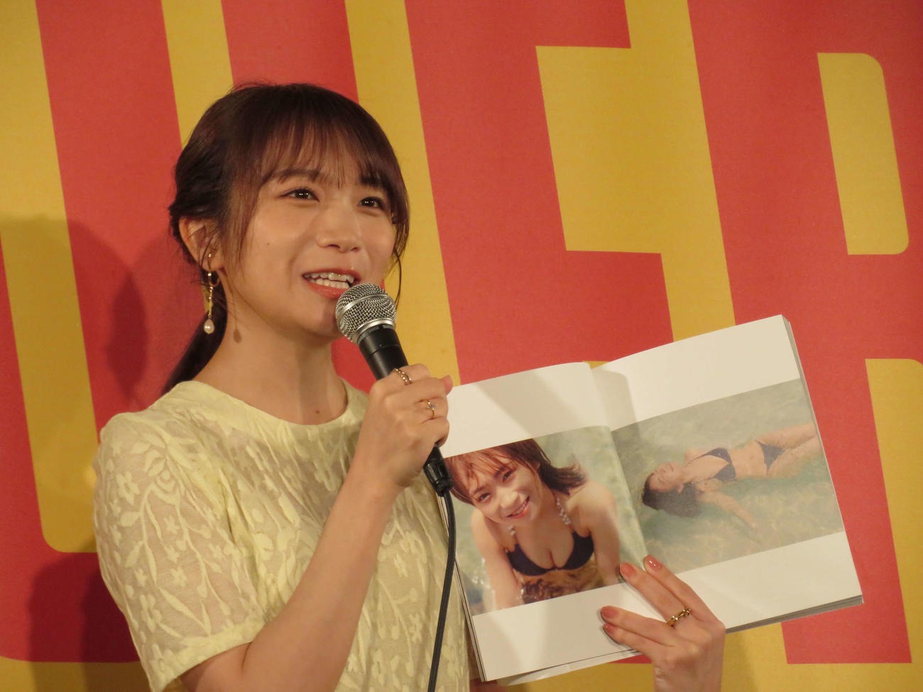 「秋元真夏フォトブック『淡淡』」刊行記念囲み取材で、お気に入りのページを開いた秋元真夏（撮影・村上幸将）