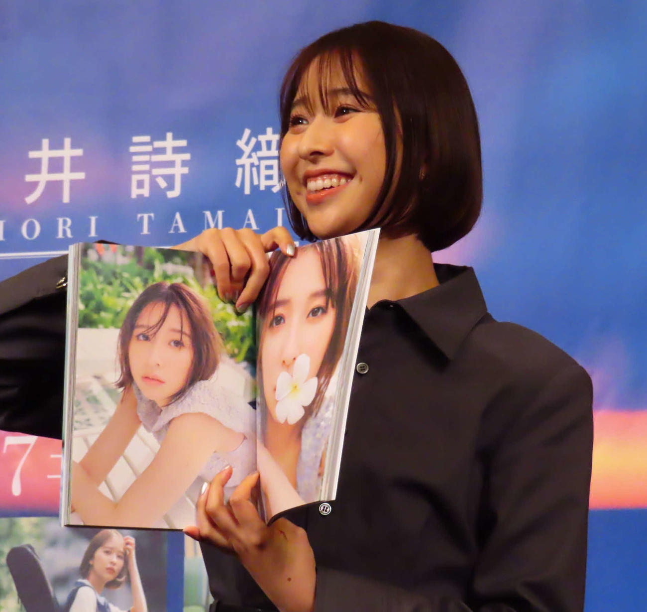 玉井詩織1st写真集「たまゆら」ストーリー写真集「しおどき」発売記念イベントで、「たまゆら」のお気に入りカットを見せる玉井詩織