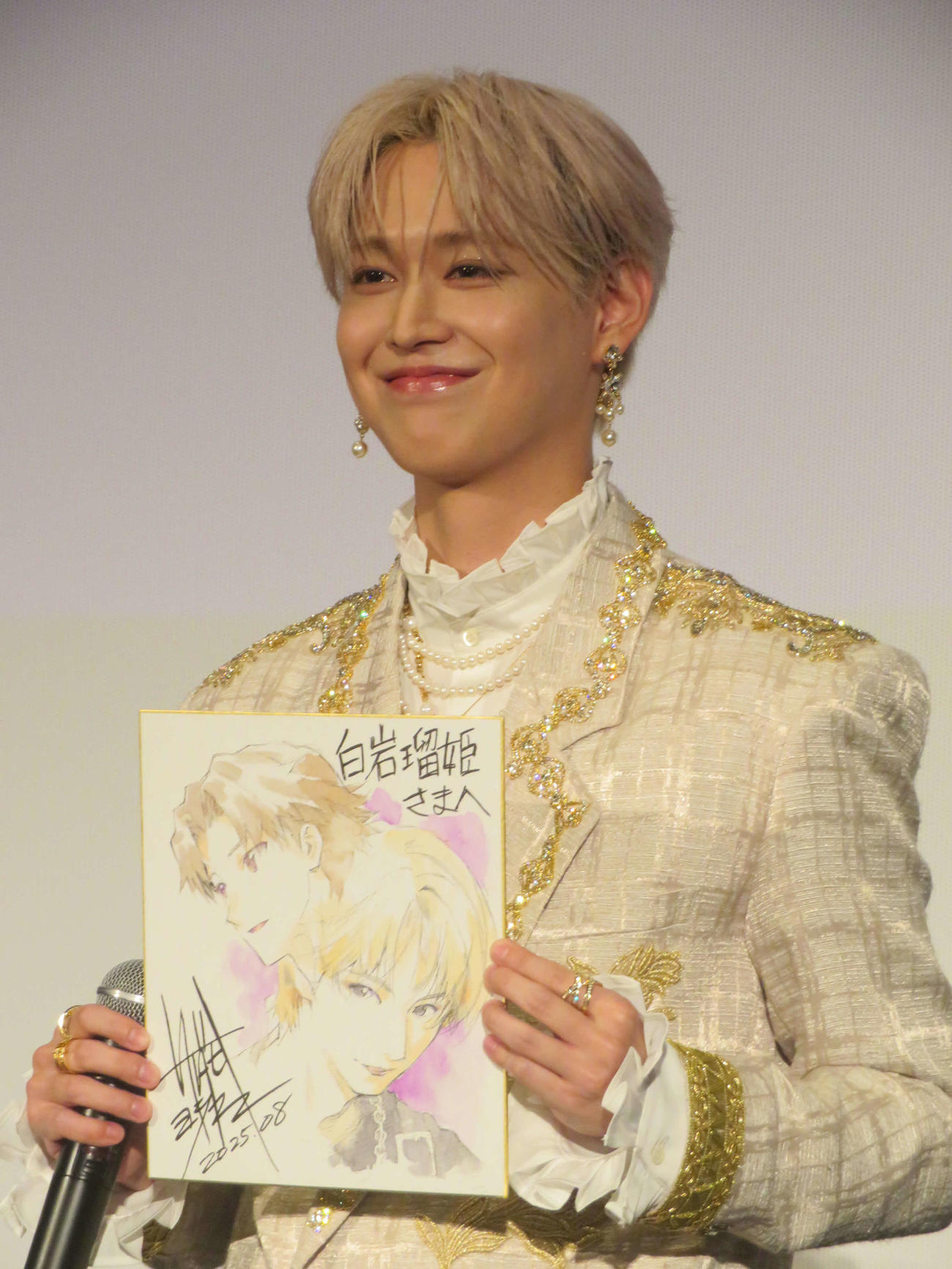 キャラクターデザインを手がけた貞本義行氏が描いたサプライズプレゼントの似顔絵に満面の笑みを浮かべる白岩瑠姫（左）（撮影・川田和博）