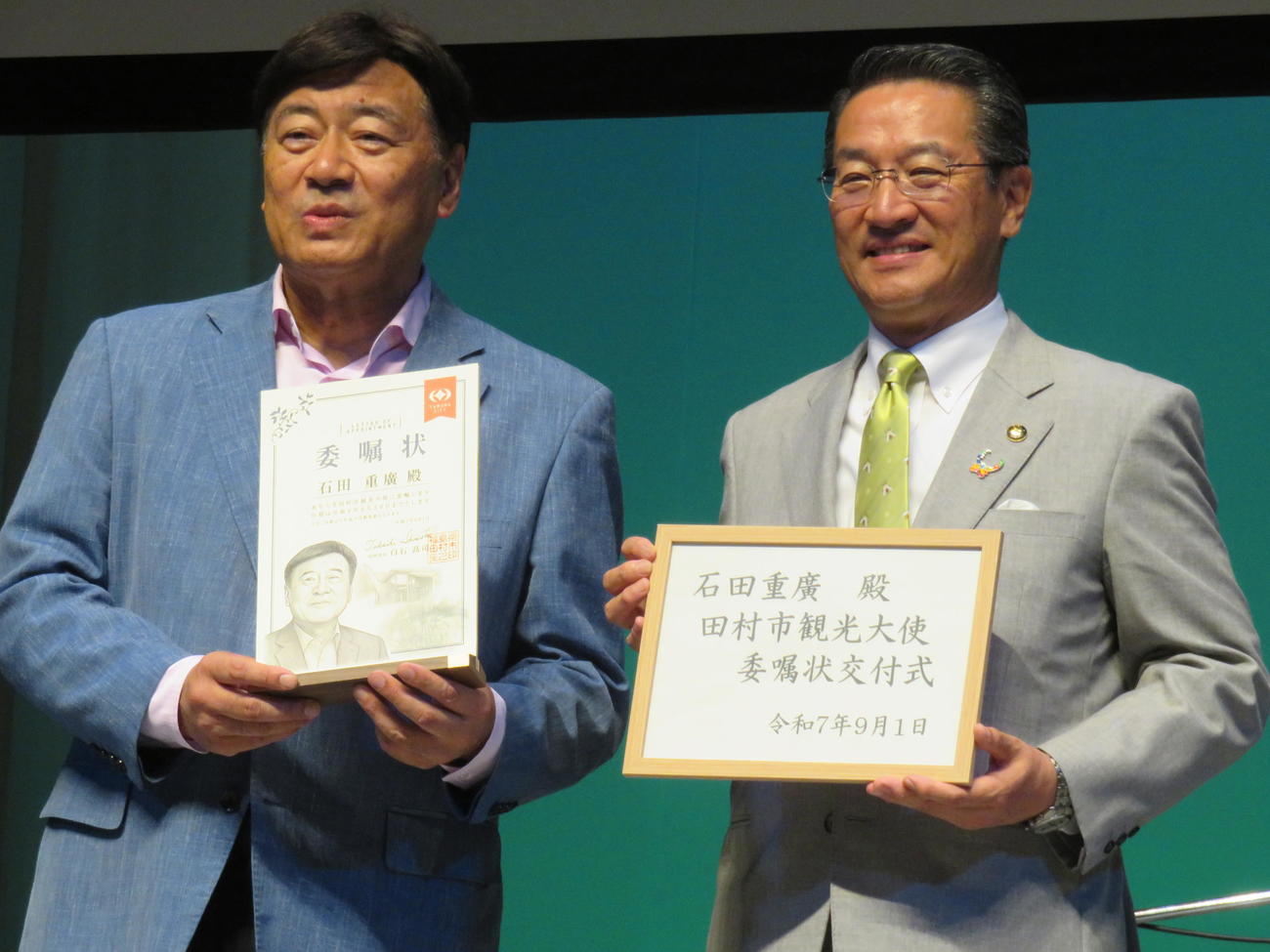 福島県田村市観光大使の委嘱状を交付された夢グループの石田重廣社長（左）。右は白石高司市長