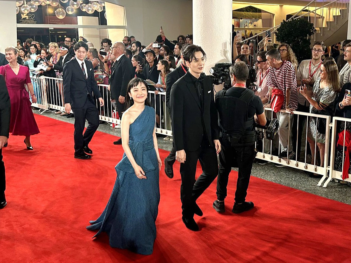 レッドカーペットを歩いて上映会場へと向かう芦田愛菜（手前）と岡田将生＝4日、イタリア・ベネチア（共同）