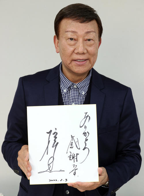 「ありがとう　感謝です」と記した色紙を持ち、笑顔を見せる橋幸夫さん（2022年4月撮影）
