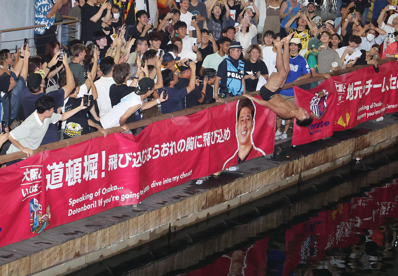 背面から道頓堀に飛び込む阪神ファン（撮影・白石智彦）