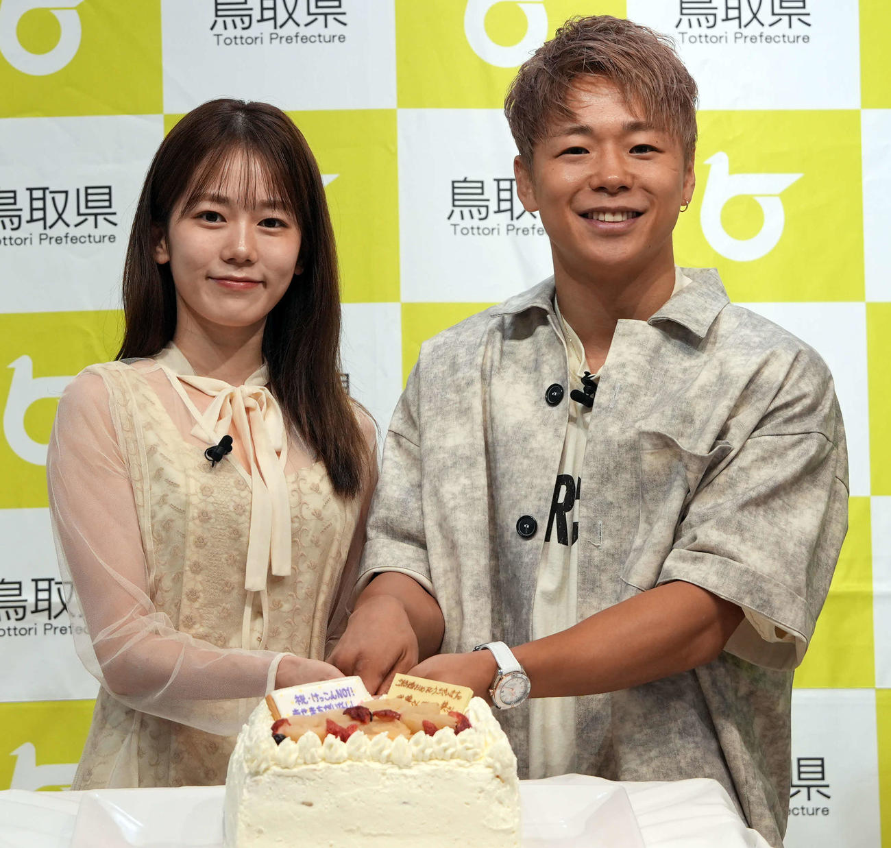 鳥取県「ベストペア（＝梨）」任命式に登場し、サプライズウエディングケーキにケーキ入刀する川口葵（左）と武尊（撮影・小島史椰）