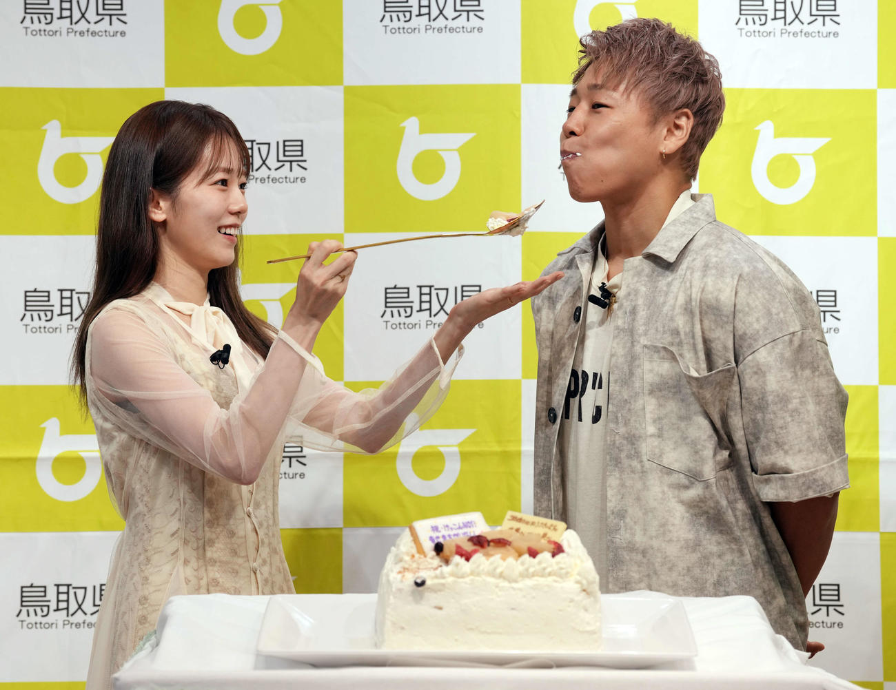 鳥取県「ベストペア（＝梨）」任命式に登場し、サプライズウエディングケーキを食べさせる川口葵（左）と武尊（撮影・小島史椰）