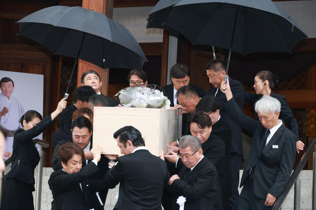 降りしきる雨の中運ばれる橋幸夫さんの棺（撮影・中島郁夫）