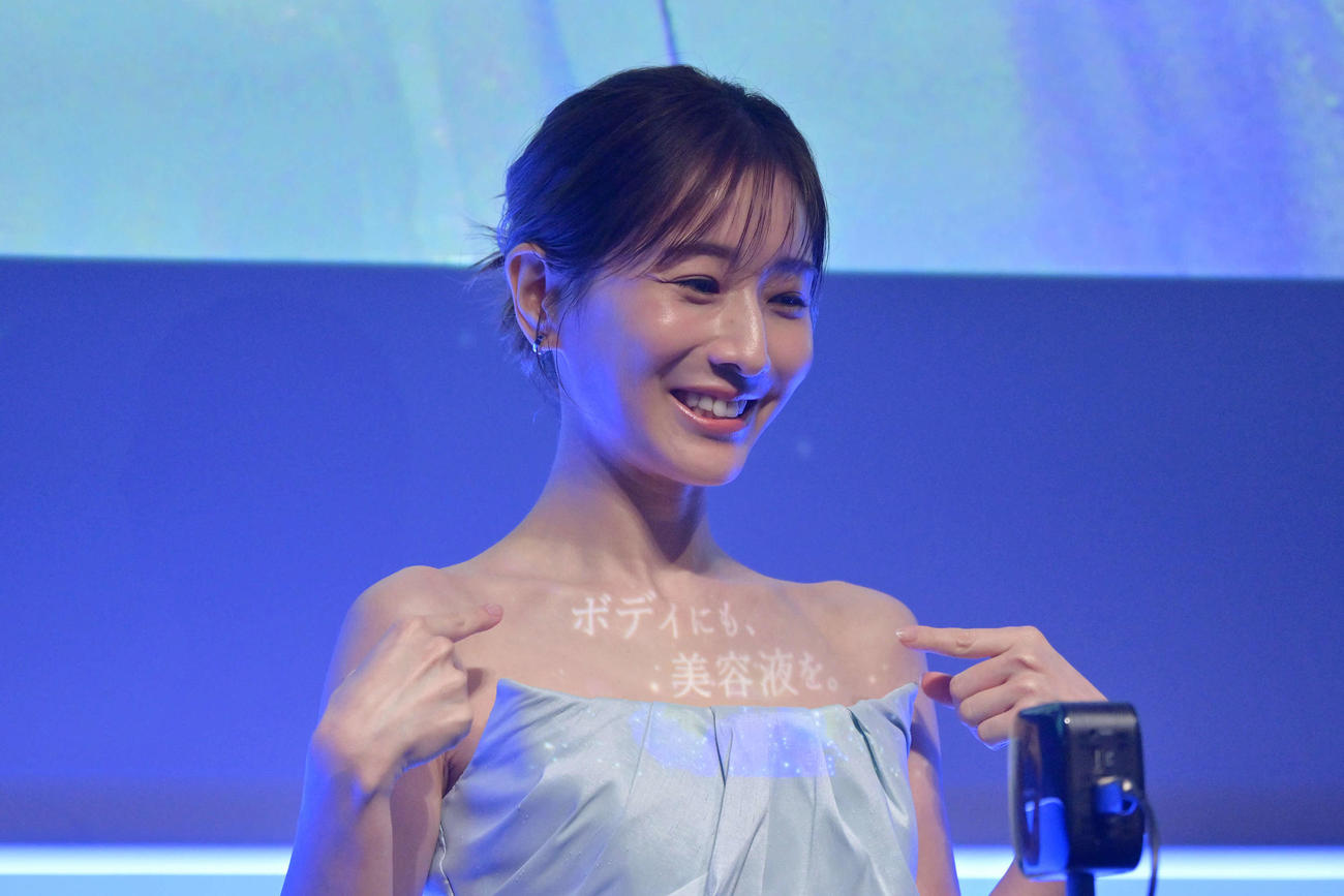 田中みな実のデコルテに映像が映し出される（撮影・滝沢徹郎）