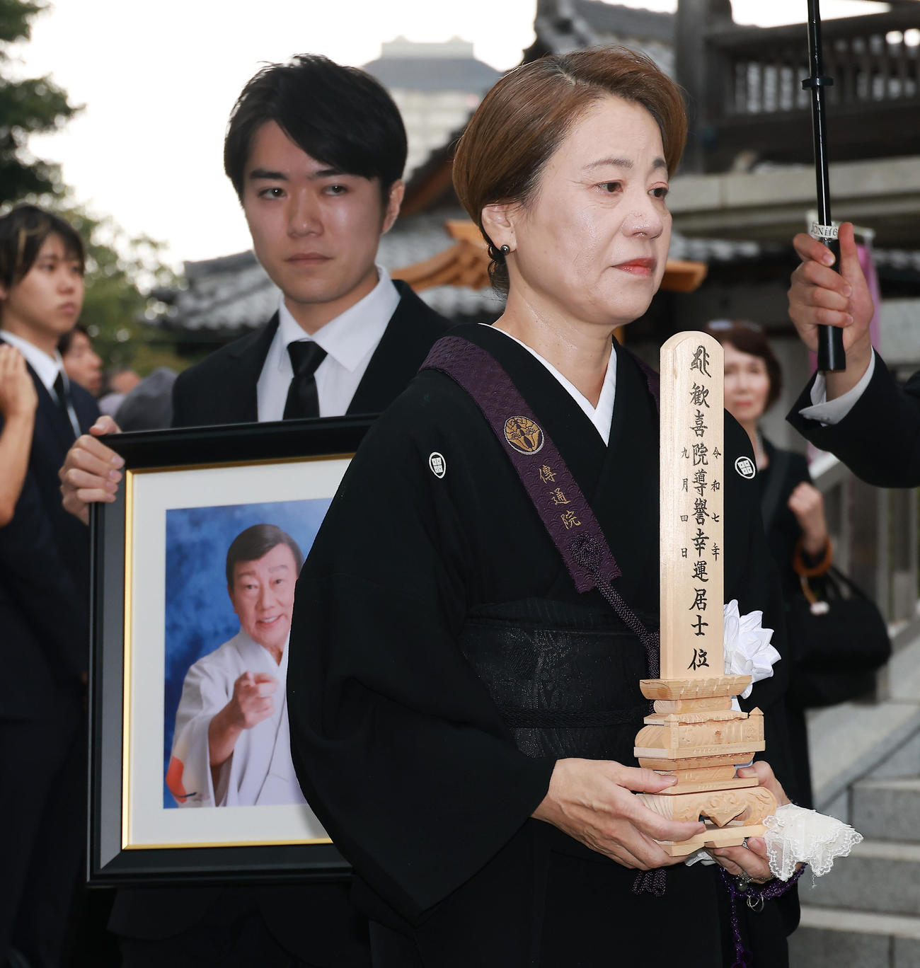 遺影を持つ二代目橋幸夫yH2徳岡純平（左）と位牌（いはい）を持つ真由美夫人（撮影・中島郁夫）