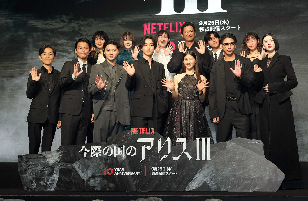 Netflix「今際の国のアリス」シーズン3のグローバルファンイベントに登壇し、記念撮影に納まる、前列左から佐藤信介監督、毎熊克哉、磯村勇斗、山﨑賢人、土屋太鳳、賀来賢人、三吉彩花。後列左から玄理、玉城ティナ、須藤理彩、池内博之、醍醐虎汰朗、吉柳咲良（撮影・たえ見朱実）