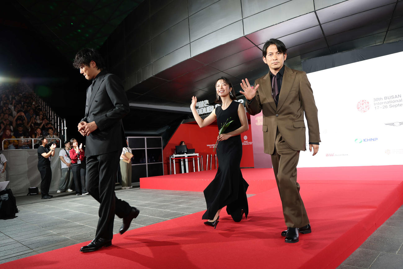 釜山国際映画祭オープニングセレモニーのレッドカーペットに登場した「イクサガミ」の、左から藤井道人監督、藤崎ゆみあ、岡田准一（C）Getty Images