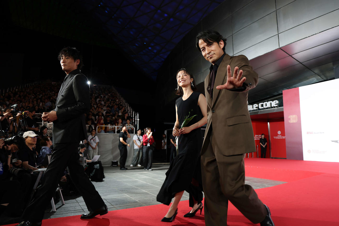 釜山国際映画祭オープニングセレモニーのレッドカーペットに登場した「イクサガミ」の、左から藤井道人監督、藤崎ゆみあ、岡田准一（C）Getty Images